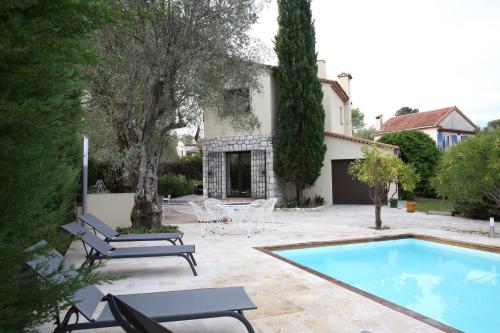 um quintal com uma piscina e uma casa em Superbe villa de charme avec piscine chauffée em Roquefort Les Pins