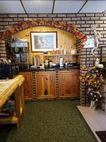 a kitchen with wooden cabinets and a brick wall at Centerstone Resort Lake-Aire in Tomahawk