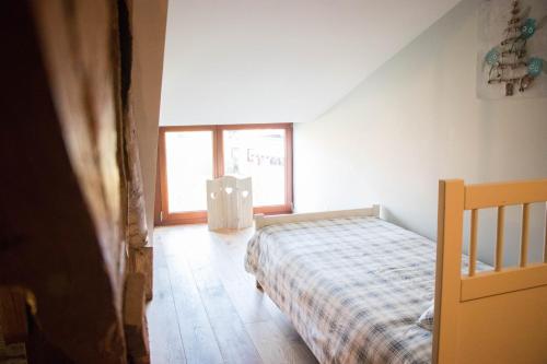 - une chambre avec un lit et une fenêtre dans l'établissement A la Grange d'en Haut, à Bras-Haut