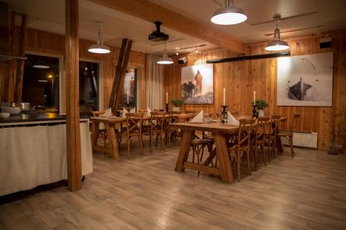 a dining room with wooden tables and chairs at Holmen Husky Lodge in Alta