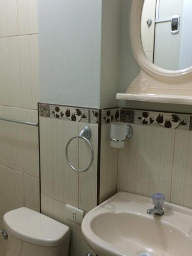 uma casa de banho com um lavatório, um WC e um espelho. em Hospedaje de los Reyes em Huarmey