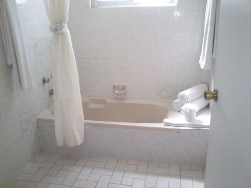 a white bathroom with a tub and a shower at Dorados Conventions & Resort in Oaxtepec