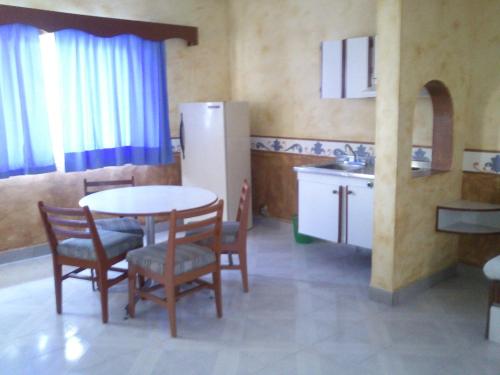 a kitchen with a table and chairs and a refrigerator at Dorados Conventions & Resort in Oaxtepec