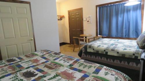 a bedroom with a bed and a window and a door at Tug Hill Resort in Redfield
