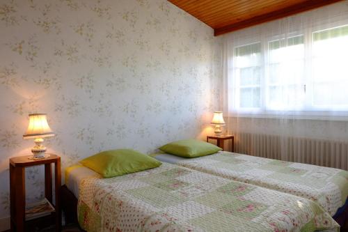 um quarto com 2 camas individuais e 2 candeeiros em B&B Le Cottage Paris Saclay em Bures-sur-Yvette