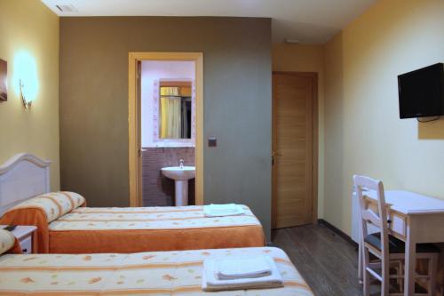 a hotel room with two beds and a sink at Hostal Regio in Madrid