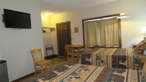 a hotel room with two beds and a table and a television at Tug Hill Resort in Redfield