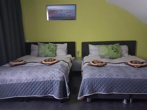 two beds sitting next to each other in a room at Sewdien’s Apartment Maashaven in Rotterdam