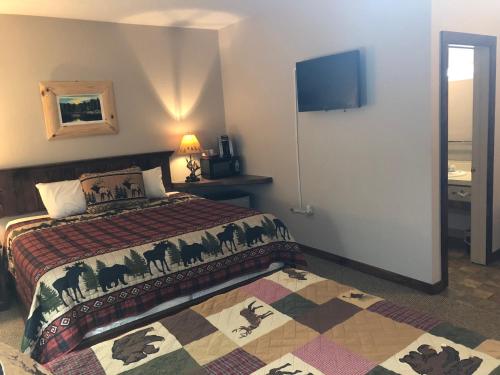a hotel room with a bed and a television at Tug Hill Resort in Redfield