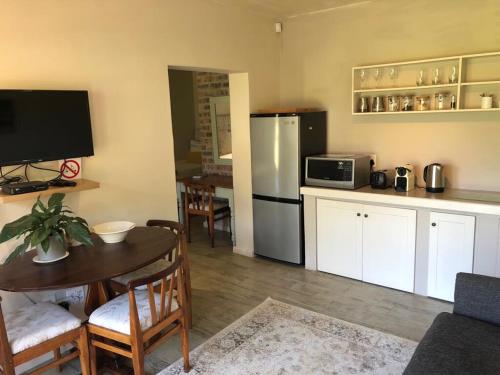 a kitchen with a table and a refrigerator at Viettz Suite in Stellenbosch
