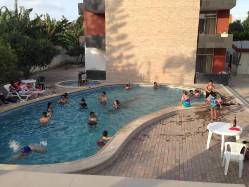 a group of people swimming in a swimming pool at Hotel Almond Beach in Tonsupa