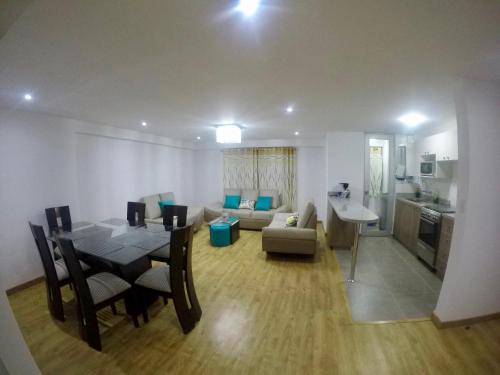 a living room with a dining table and a kitchen at Casona Apartament in Arequipa