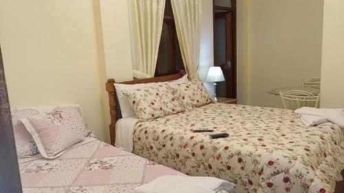 Sayán的住宿－Hotel Elizabeth Hoss，一间卧室配有两张床和一张桌子