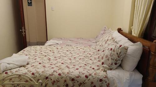a bedroom with a bed with a floral comforter at Hotel Elizabeth Hoss in Sayán