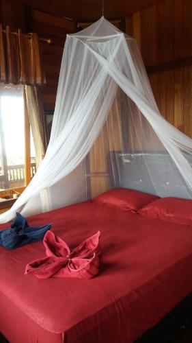 A bed or beds in a room at Sunset Guest House & Bar