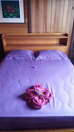 a purple bed with a purple blanket on it at Sunset Guest House & Bar in Bunaken