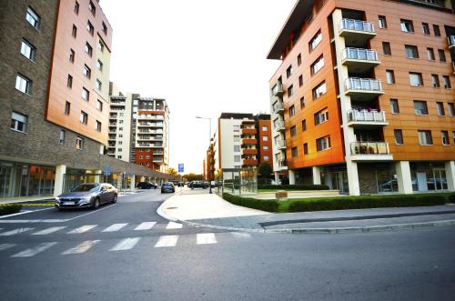 a car driving down a city street with buildings at Clean&Cozy Apartments Novi Beograd in Belgrade