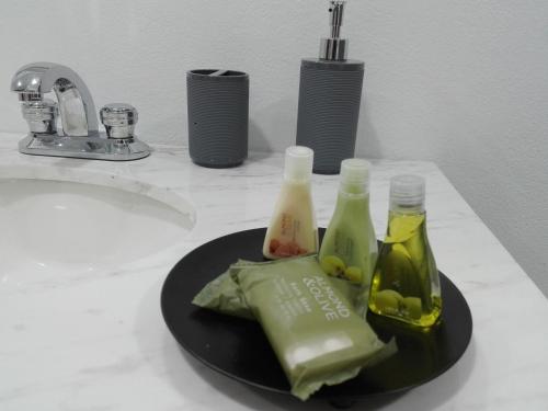 a black plate with two bottles on a bathroom counter at MV Suites Suc. Capilla in Monterrey