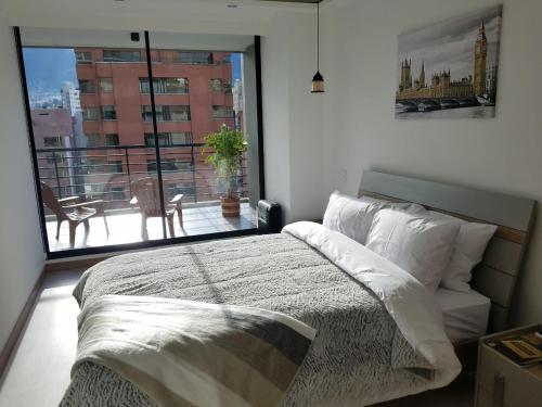 a bedroom with a bed and a large window at Luxury Residence Suites in Quito