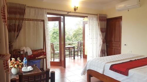 a bedroom with a bed and a balcony at Cozy Son Hotel in Ninh Binh