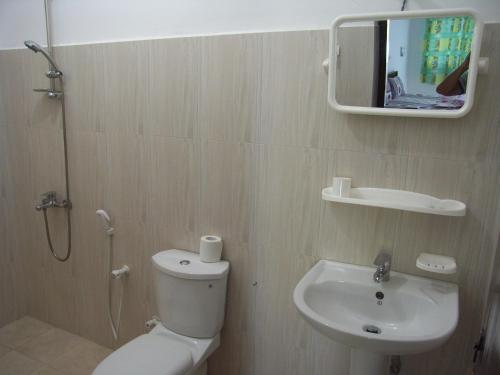 ein Badezimmer mit einem WC, einem Waschbecken und einem Spiegel in der Unterkunft Bochum Lanka Resort in Beruwala