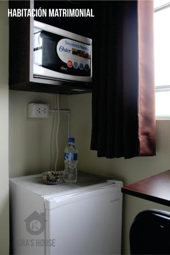 a microwave on top of a refrigerator in a kitchen at Kira's House in Piura