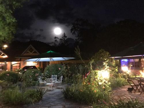a full moon over a garden at night at Pousada Terra da Luz in Visconde De Maua