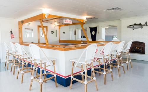 a group of chairs lined up at a bar at Wylder Hotel - Tilghman Island in Saint Michaels