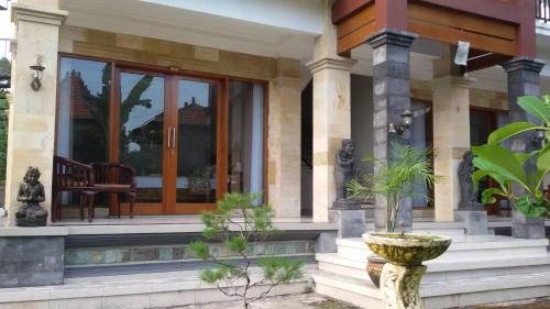 a house with a porch with a chair in it at Murdhasari in Ubud