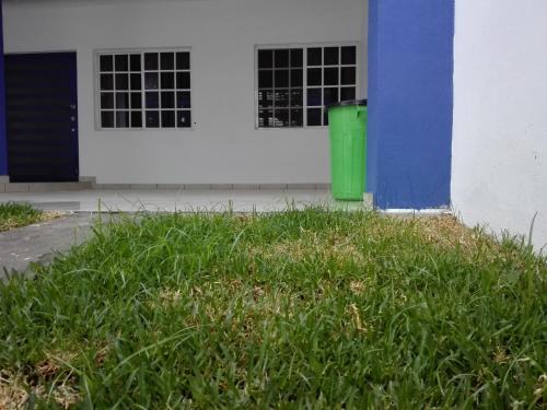 a green trash can in front of a building at MV Suites Suc. Capilla in Monterrey