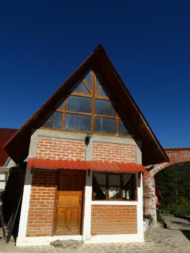 a small brick building with a large window at Posada Santa María in Mineral del Chico