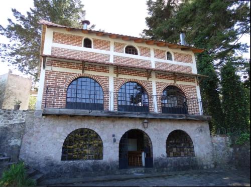 an old brick building with a balcony on top of it at Posada Santa María in Mineral del Chico