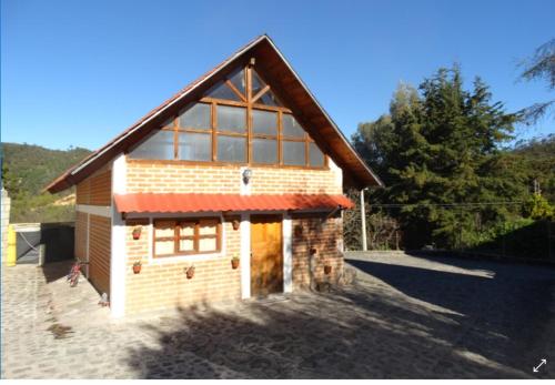 a small brick building with a red roof at Posada Santa María in Mineral del Chico