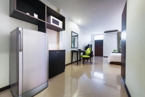 a white refrigerator in a room with a bedroom at Capital Mansion - SHA Certified in Bangkok