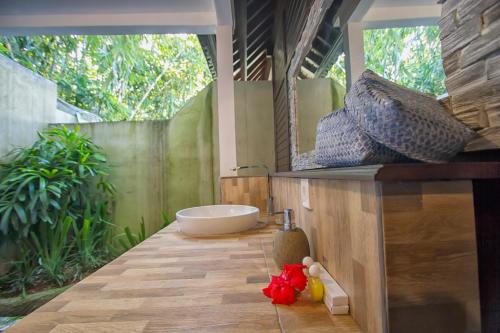 y baño con bañera y lavamanos. en Villa Wedang en Tegalalang