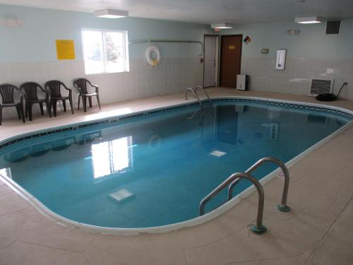 a large swimming pool with chairs and a table at SureStay Plus Hotel by Best Western Bettendorf in Bettendorf