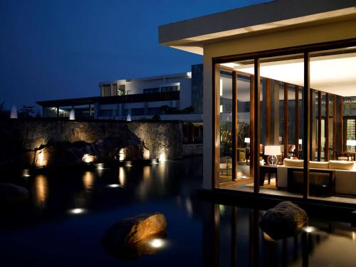a house with a pool in front of a building at Hyatt Hyderabad Gachibowli in Hyderabad