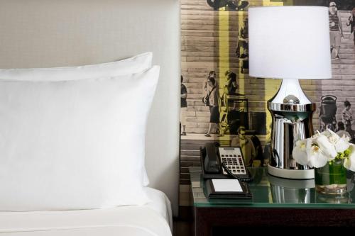 a bedroom with a bed and a table with a lamp at Hyatt Centric Arlington in Arlington