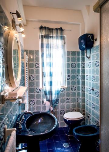 a blue tiled bathroom with a sink and a toilet at Casa vacanze Maradei in Scalea
