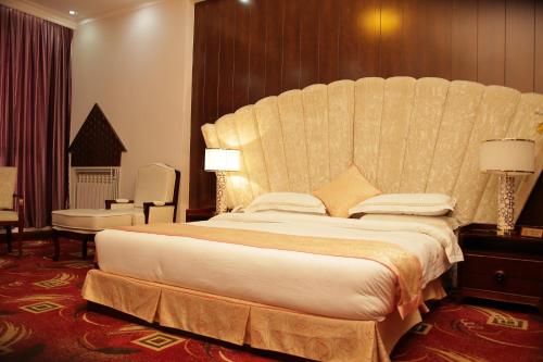 a large bed with a large headboard in a hotel room at Kabul Star Hotel & Restaurant in Shīrpūr
