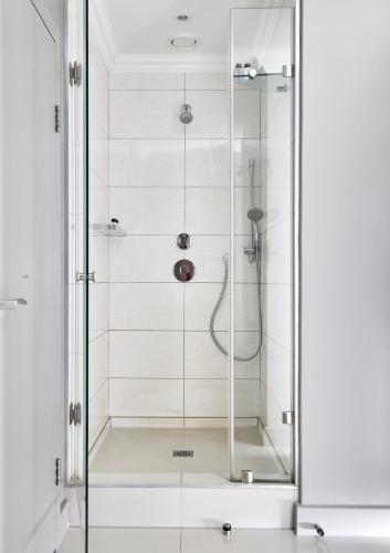 a shower with a glass door in a bathroom at Queen Victoria Hotel by NEWMARK in Cape Town