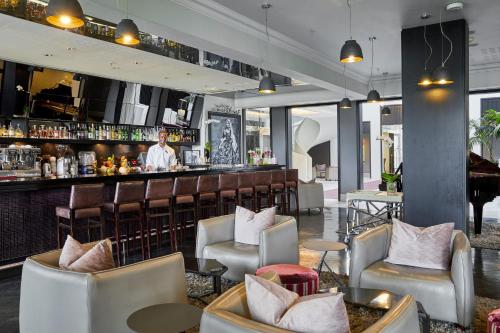 a bar at a hotel with chairs and a bartender at Queen Victoria Hotel by NEWMARK in Cape Town