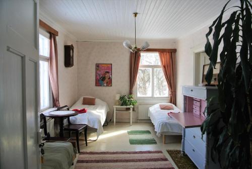Zimmer mit 2 Betten und einem Tisch in der Unterkunft Villa Dönsby in Karjaa