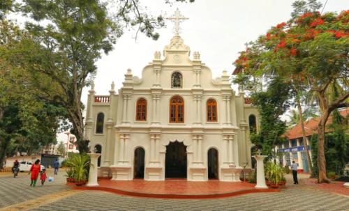 a large white church with a cross on the front at Padamadan homestay in Cochin