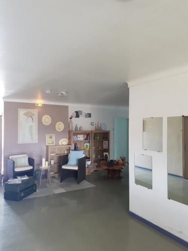 a living room with blue chairs and a white wall at Hotel Carina in Apt