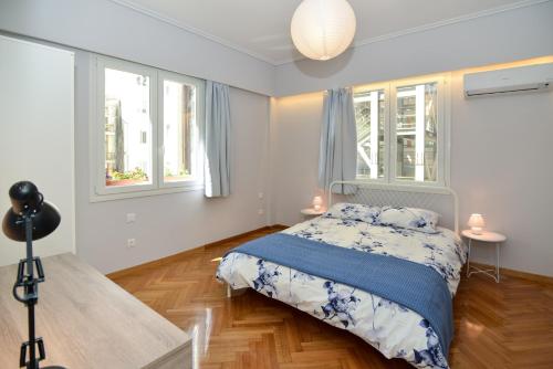 a bedroom with a bed and two windows at Athens' heart Syntagma metro apartment in Athens