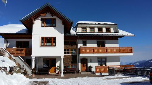 a large white house with snow on the ground at Kirchenbichlerhof in Pruggern