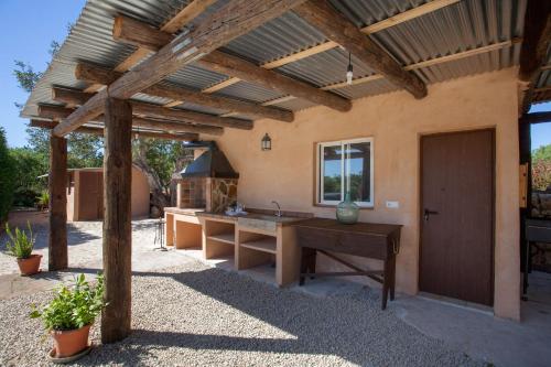 an outdoor kitchen with a wooden pergola at Es Mitja Davall in Sencelles