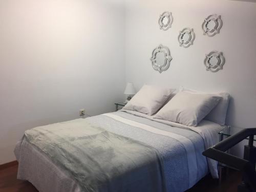 1 dormitorio blanco con 1 cama con 2 almohadas en Apartamento Arco del Cristo, en Cáceres