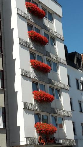 
a row of windows with flowers in front of them at City-Hotel garni in Neu-Ulm

